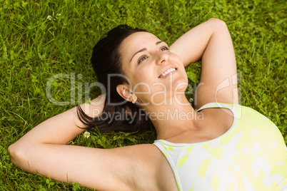 Relaxed fit brunette lying on grass