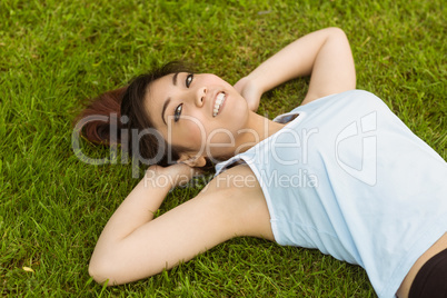 Healthy and beautiful woman lying on grass in park