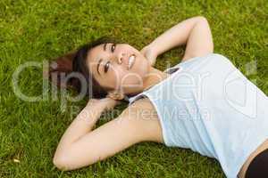 Healthy and beautiful woman lying on grass in park