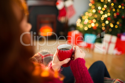 Redhead enjoying coffee on the armchair at christmas