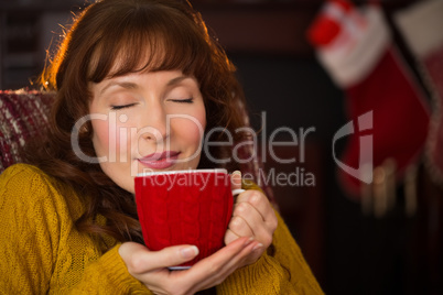 Beautiful redhead enjoying hot drink at christmas