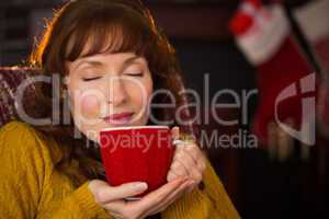 Beautiful redhead enjoying hot drink at christmas