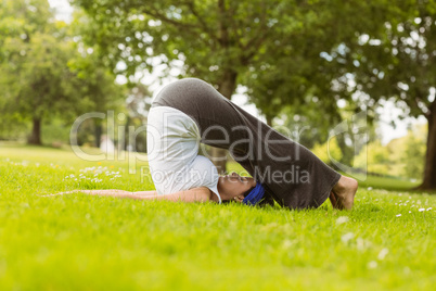Brown hair doing yoga on grass