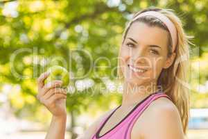 Fit blonde holding green apple