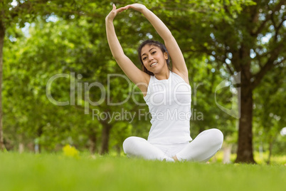 Healthy woman stretching hands in park