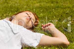 Pretty redhead napping on grass