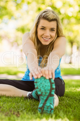 Fit blonde stretching on the grass