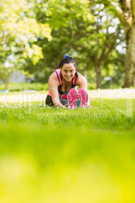 Fit brunette warming up on the grass