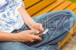 Woman sitting on bench texting