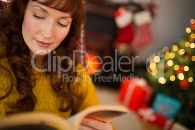 Calm redhead reading a book at christmas