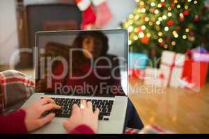 Rear view of redhead typing on laptop at christmas