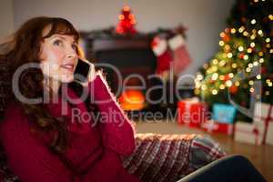 Smiling redhead on the phone at christmas