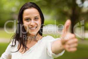 Positive casual brunette with thumbs up