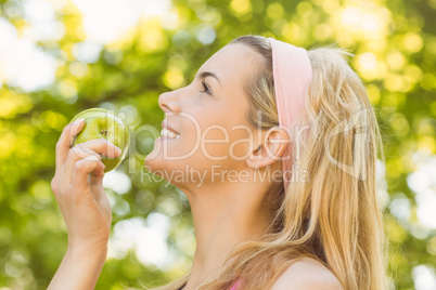 Fit blonde holding green apple