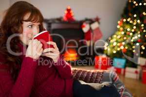 Pretty redhead drinking hot drink at christmas