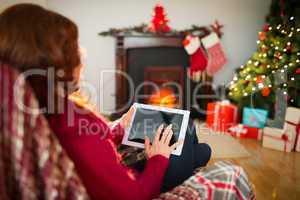 Redhead touching digital tablet at christmas