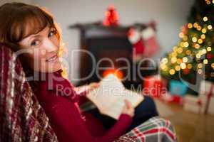 Happy redhead reading a book at christmas