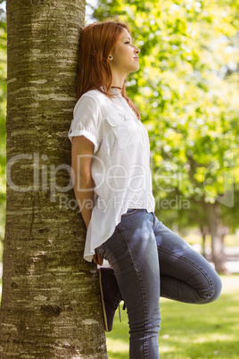 Portrait of a pretty redhead leaning against trunk Portrait of a pretty redhead leaning against trunk