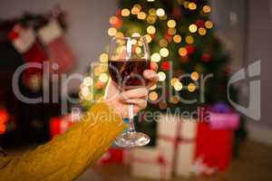 Woman sitting on a couch while holding a glass of red wine
