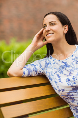 Happy brunette sitting on bench relaxing