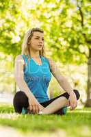 Fit blonde sitting on the grass