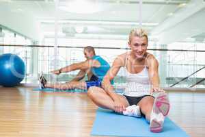 Couple stretching hands in yoga class