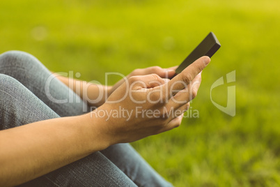 Mid section of a pretty redhead with her mobile phone