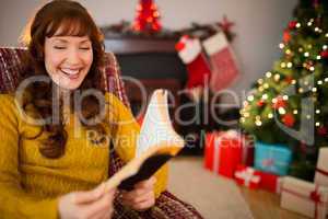 Happy redhead reading on the armchair at christmas