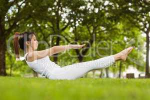 Side view of doing the boat pose in park