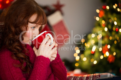 Beautiful redhead drinking hot drink at christmas