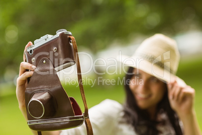 Smiling brunette taking a selfie with retro camera