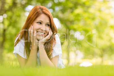 Portrait of a pretty redhead happy and lying