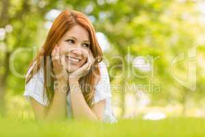 Portrait of a pretty redhead happy and lying