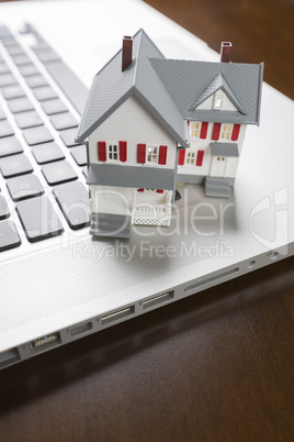 Miniature House on Laptop Computer