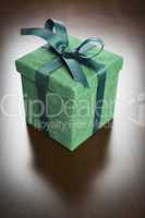 Green Gift Box with Ribbon and Bow Resting on Wood