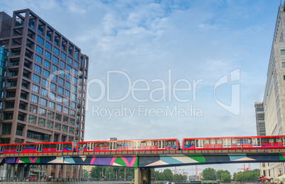 LONDON - AUG 20, 2013: Red train crosses river between Canary Wh