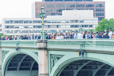 LONDON - AUG 23, 2013: Tourists walk along Westminster Bridge. L