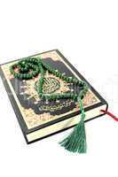 zugeschlagener Koran mit grünem Rosenkranz