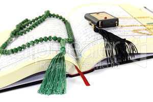 aufgeschlagener Koran mit grünem Rosenkranz