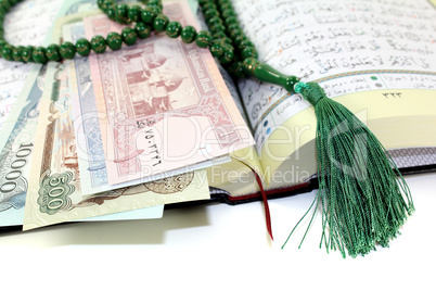aufgeschlagener Koran mit afghanistanischer Währung