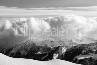 Black and white snowy mountains in clouds and off-piste slope