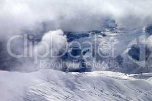 Off-piste slope in sunlight clouds