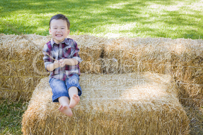 Cute Young Mixed Race Boy Having Fun on Hay Bale