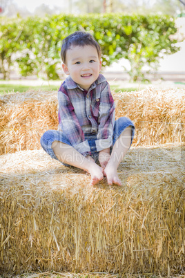 Cute Young Mixed Race Boy Having Fun on Hay Bale