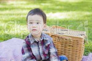 Young Mixed Race Boy Sitting in Park Near Picnic Basket