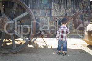 Cute Young Mixed Race Boy Having Fun Near Antique Machinery