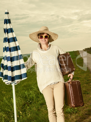 Woman wearing sun screen and holiday suitcase