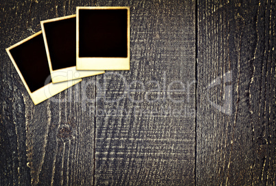 Old weathered blank instant photos on dark wooden table Old weathered blank instant photos on dark wooden table
