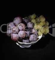 vase with grapes on a black background