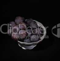 vase with grapes on a black background